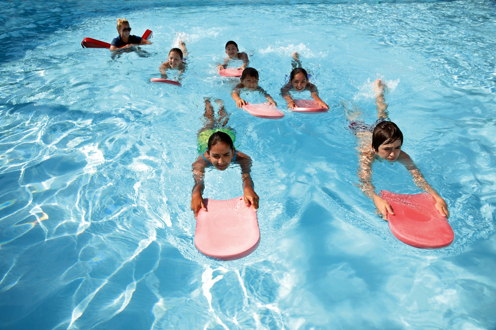 Happy children learning to swim